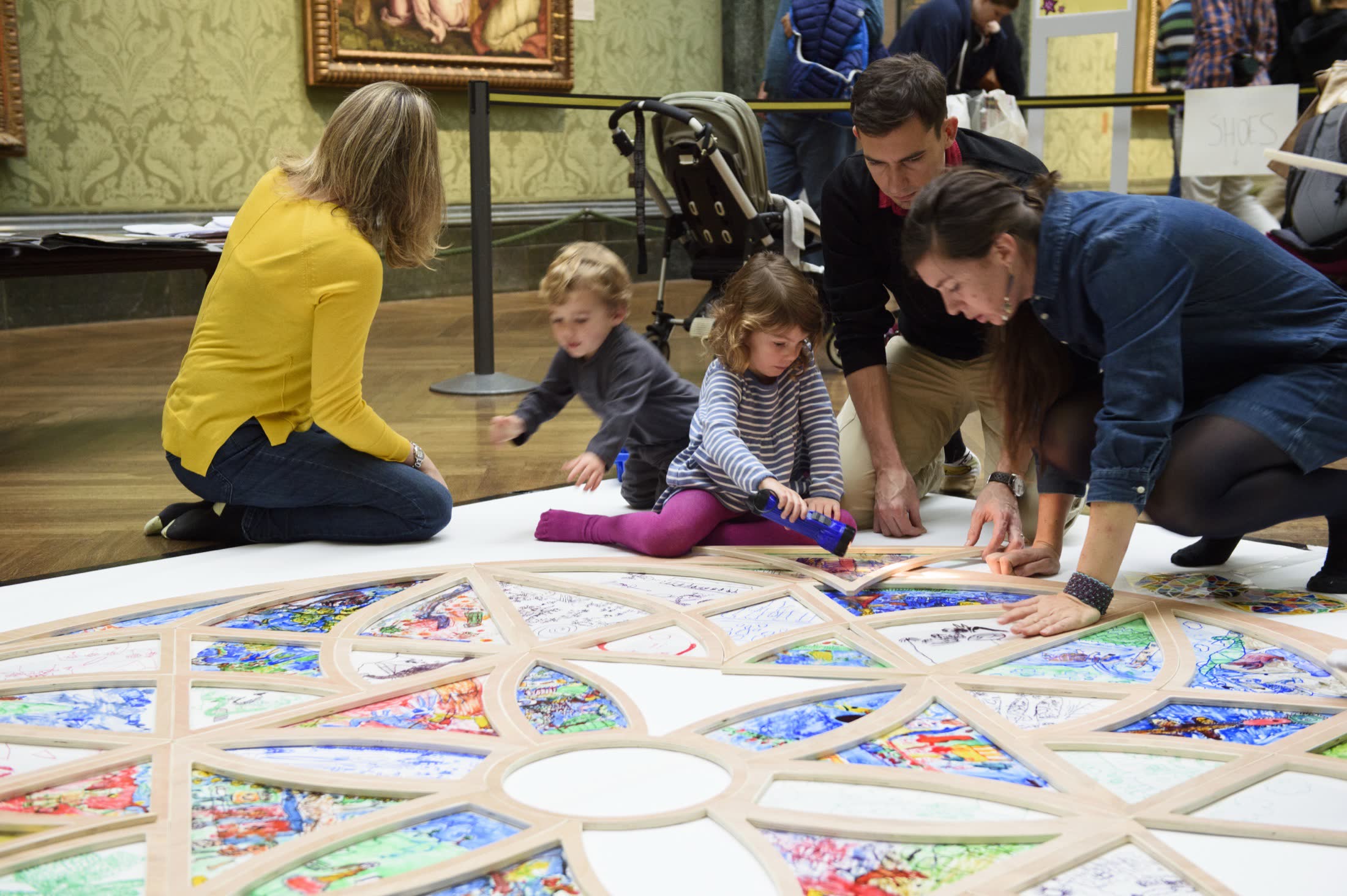Families creating together around a colourful artwork