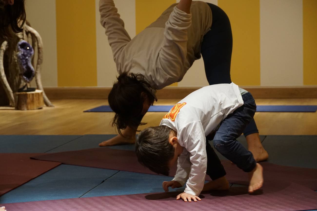 A child in playful movement, supported by an adult