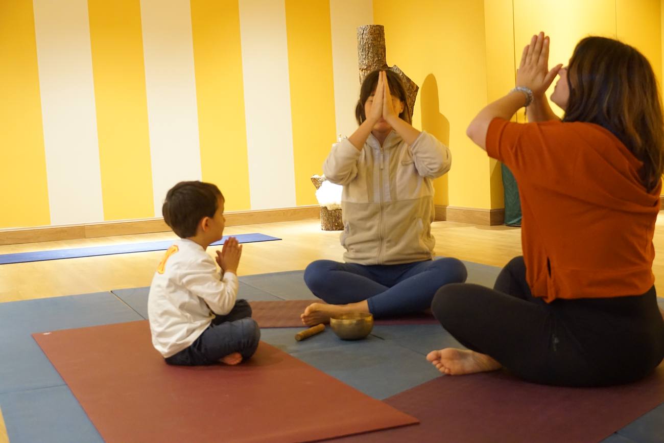A child sitting quietly with hands together in a still moment